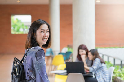 Portrait of smiling young woman using mobile phone