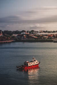 Ship sailing in sea against sky in city