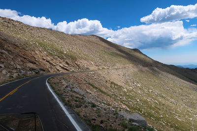 Scenic view of road by mountains against sky