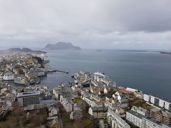 High angle view of townscape by sea against sky