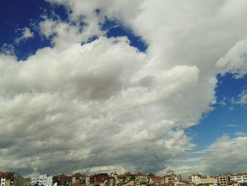 View of cityscape against cloudy sky