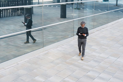 Rear view of woman walking on footpath