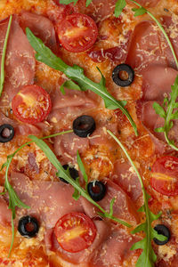 Texture of pizza with prosciutto and tomatoes