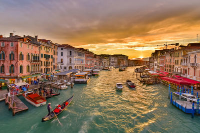 Boats in canal at sunset