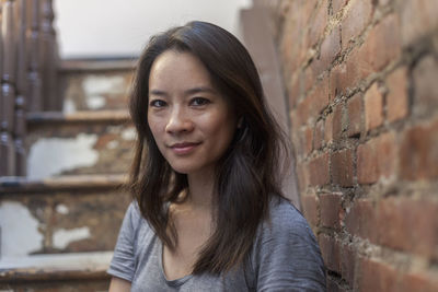 Portrait of young woman against wall