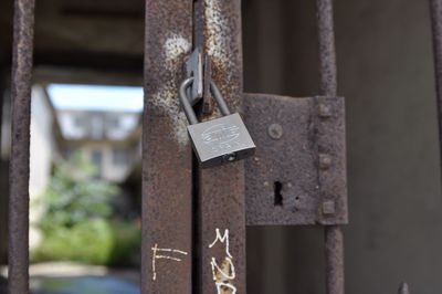 Low angle view of padlock on rusty metallic gate