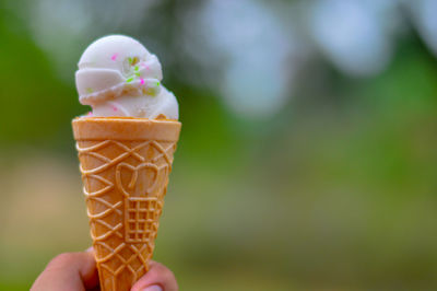 Close-up of hand holding ice cream cone