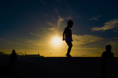 Silhouette man playing at sunset