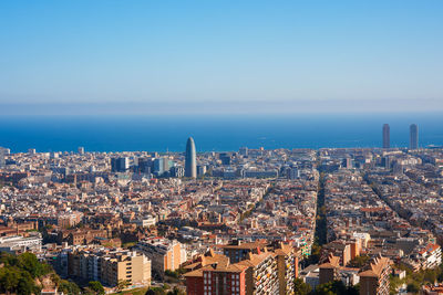 Aerial view of cityscape against clear blue sky