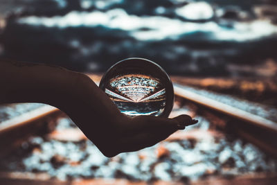 Close-up of hand holding crystal ball