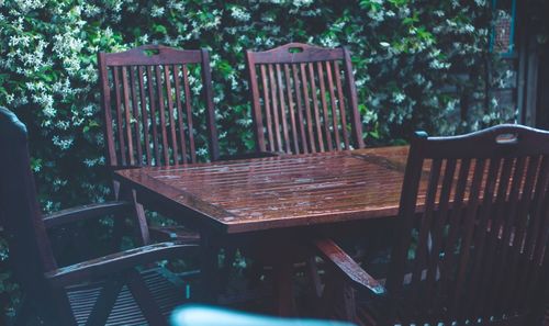 Empty chairs and table against trees