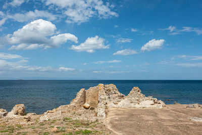 Ancient roman ruins on the seashore with cloudy sky