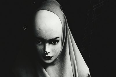 Close-up portrait of young woman in darkroom