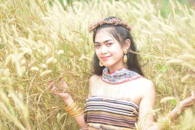 Portrait of beautiful young woman standing on field