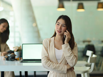 Businesswoman talking over mobile phone in office