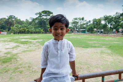 Portrait of smiling boy standing against plants