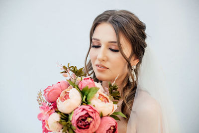 Portrait of woman against white roses