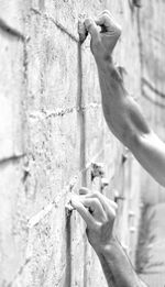 Close-up of hands touching wall