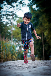 Full length of cute boy running on plant