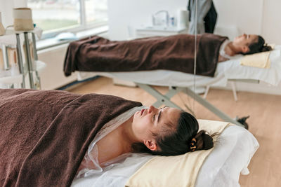 Young woman relaxing on massage table in spa