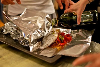 Woman pouring oil on fish