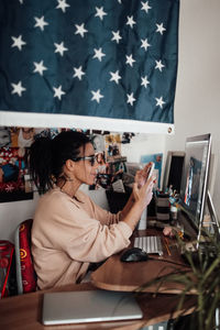 Woman using mobile phone while sitting on table