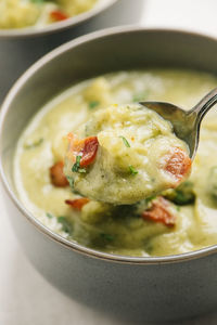 Spoonful closeup of potato and broccoli soup with bacon