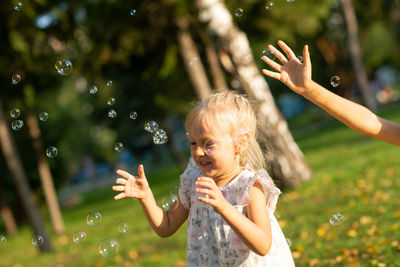 Full length of woman playing with bubbles