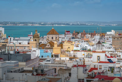 High angle view of townscape by sea against sky