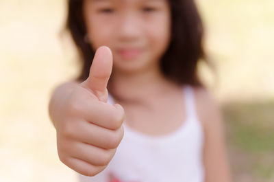 Portrait of girl gesturing thumbs up