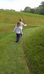 Full length of father and daughter playing on field