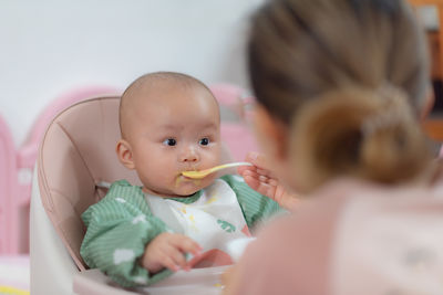 Close-up of cute baby girl sitting at home