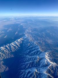High angle view of snowcapped mountains against blue sky