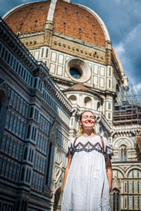 Low angle view of woman standing against building