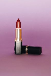 Close-up of electric lamp on table against pink background