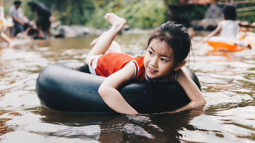 Smiling girl relaxing on inflatable ring floating in lake