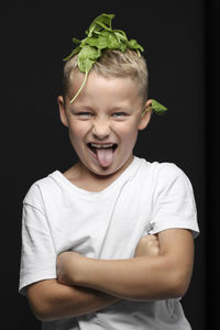 Portrait of smiling boy against black background