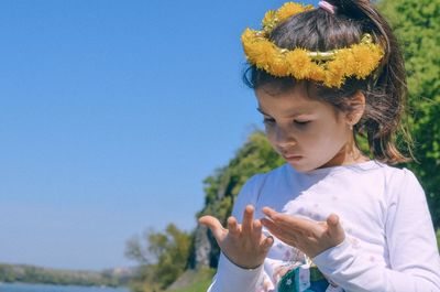 Girl standing against blue sky