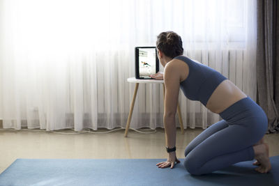 Side view of woman searching yoga tutorials