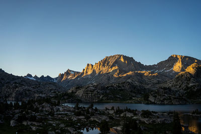 Scenic view of lake and mountains against clear sky