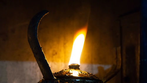 Close-up of lit oil lamp at home