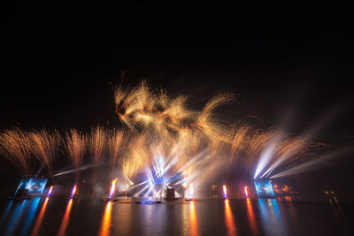 Firework display over river at night