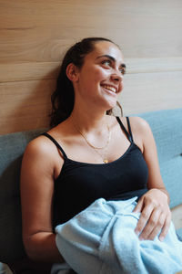Portrait of a smiling young woman sitting at home