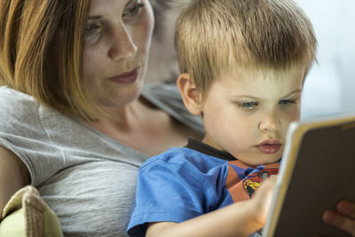 Close-up of mother and boy with digital tablet