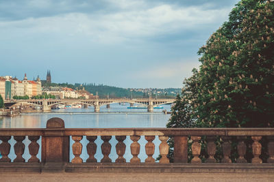 Bridge over river in city against sky