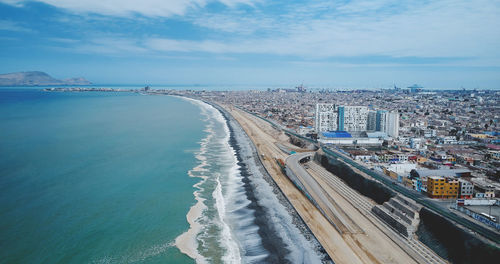 High angle view of city by sea against sky