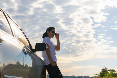Full length of man standing on car against sky