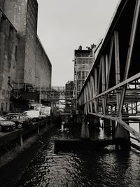 Cars on bridge in city against sky