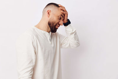 Side view of senior man standing against white background