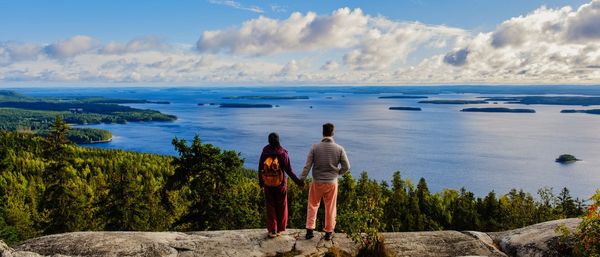 Rear view of man standing on beach against sky